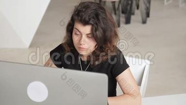 卷毛和穿孔的女人正在电脑上<strong>认真工</strong>作。